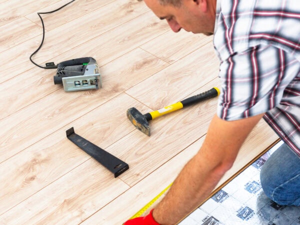 Handyman installing new laminated wooden floor