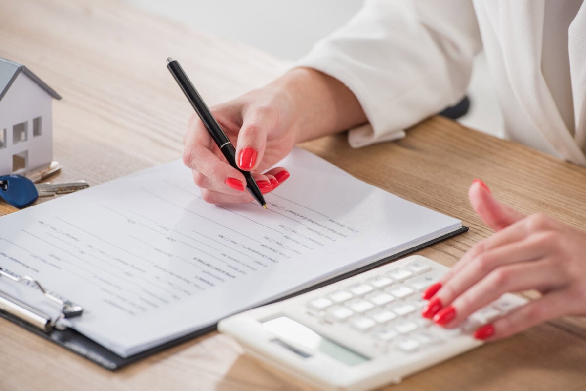 cropped view businesswoman using calculator